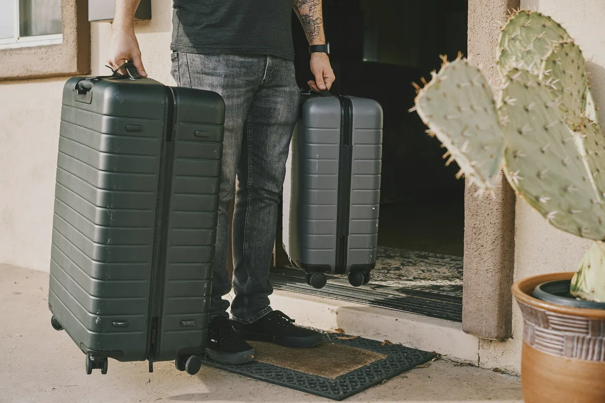 A guest with two suitcases on the doorstep of an apartment